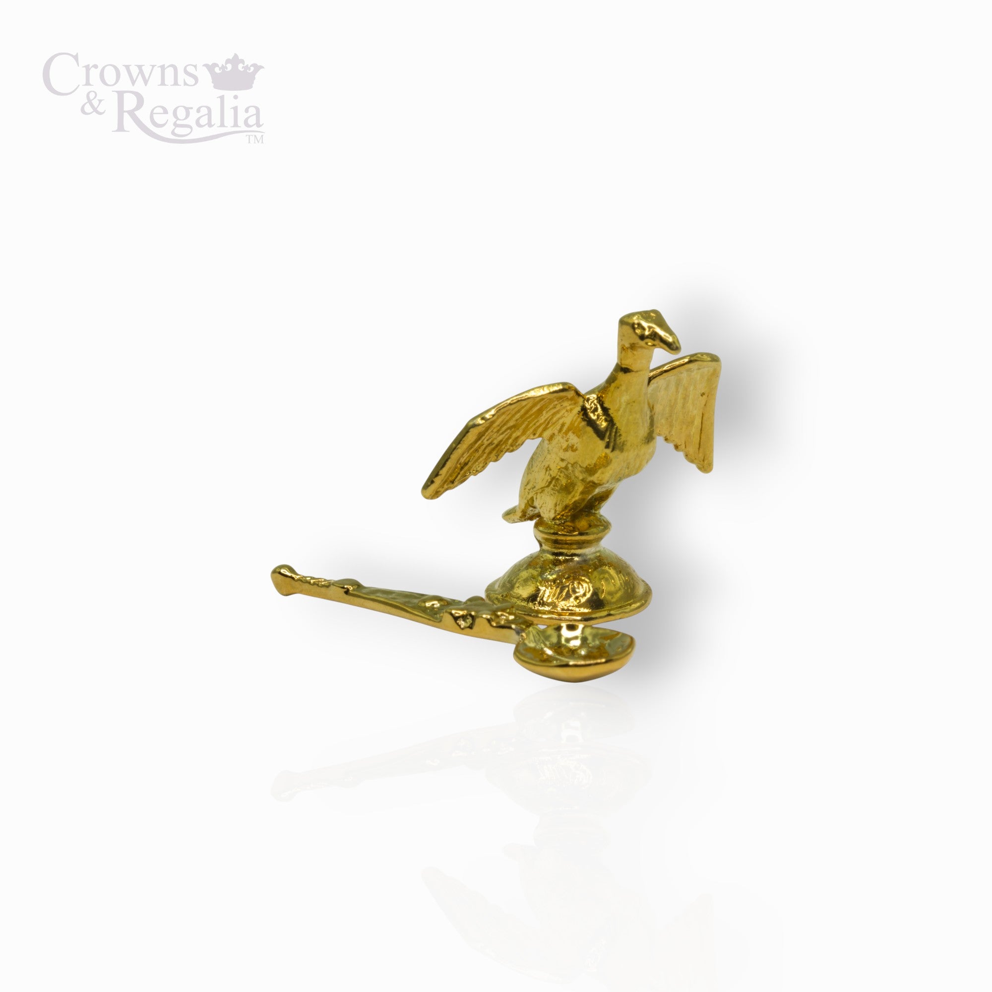 Gold decorative item with a bird design on a white background