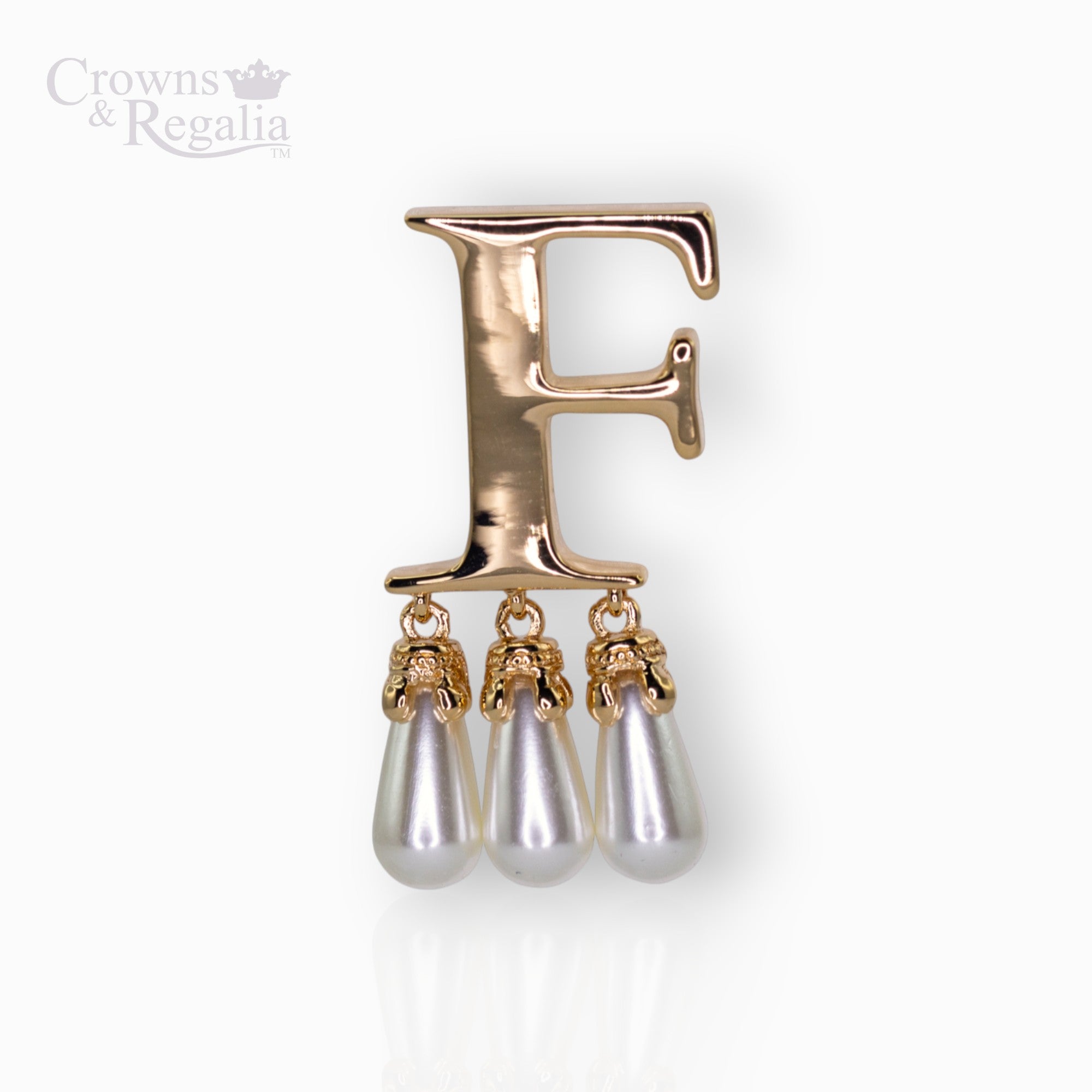 Gold brooch with letter 'F' and pearl-like droplets on a white background, branded 'Crowns & Regalia'.