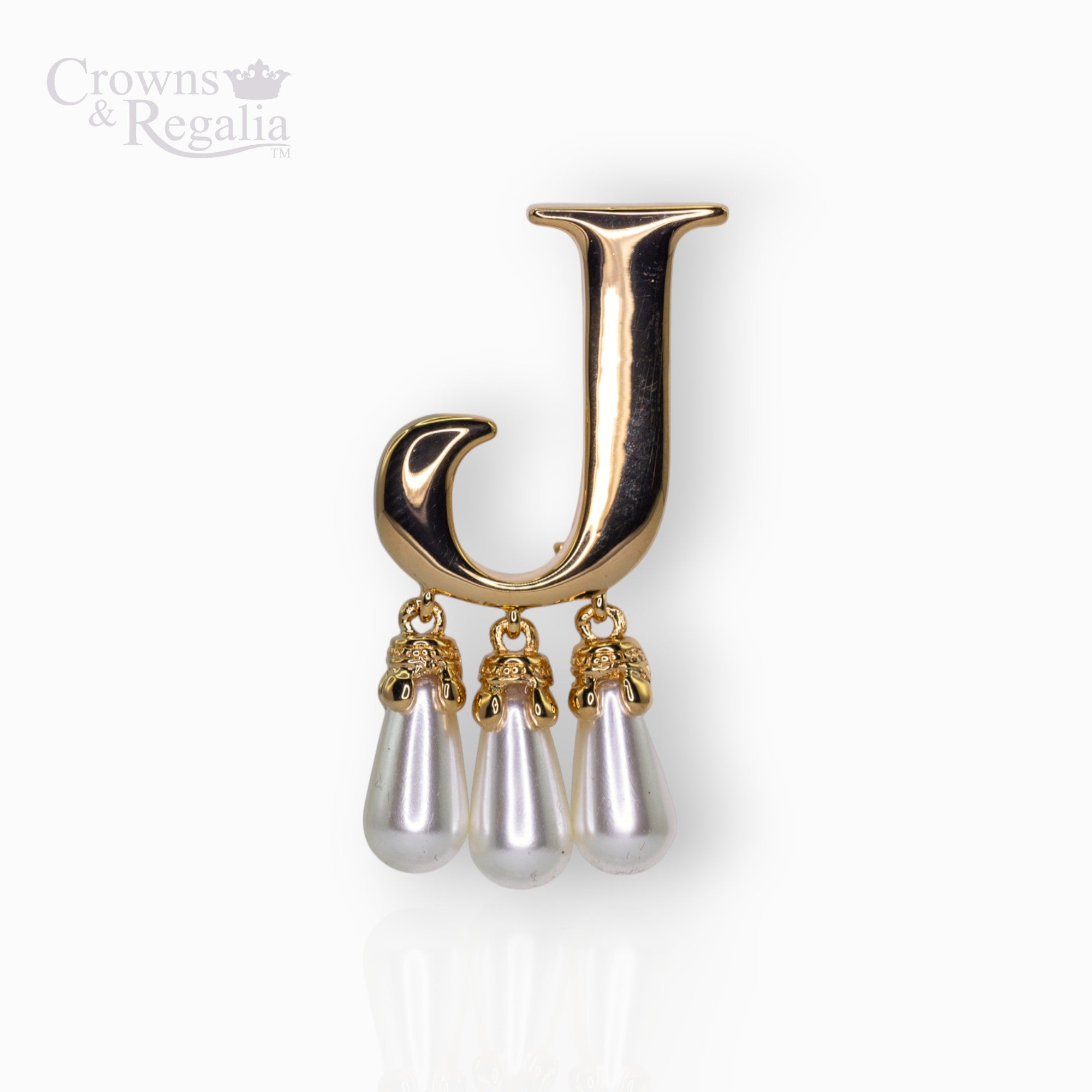 Gold brooch with letter 'J' and pearl-like droplets on a white background, branded 'Crowns & Regalia'.