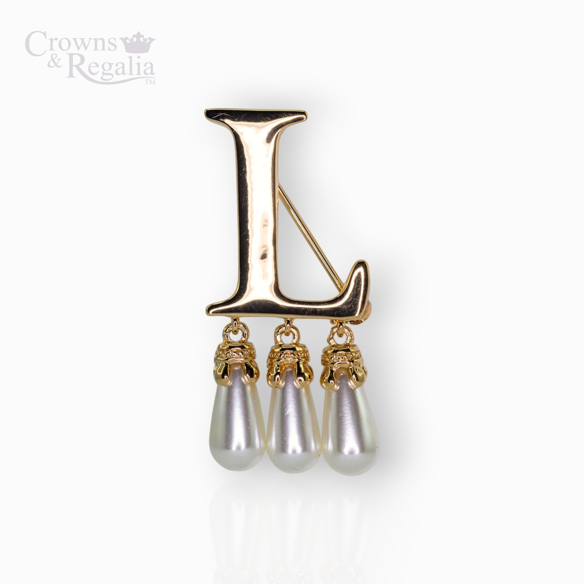 Gold brooch with 'L' and pearl-like droplets on a white background, branded 'Crowns & Regalia'.