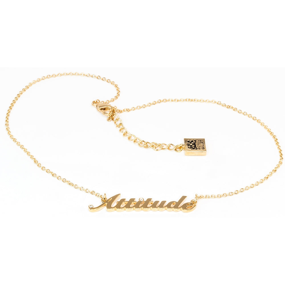 Gold necklace with 'Attitude' pendant on a white background