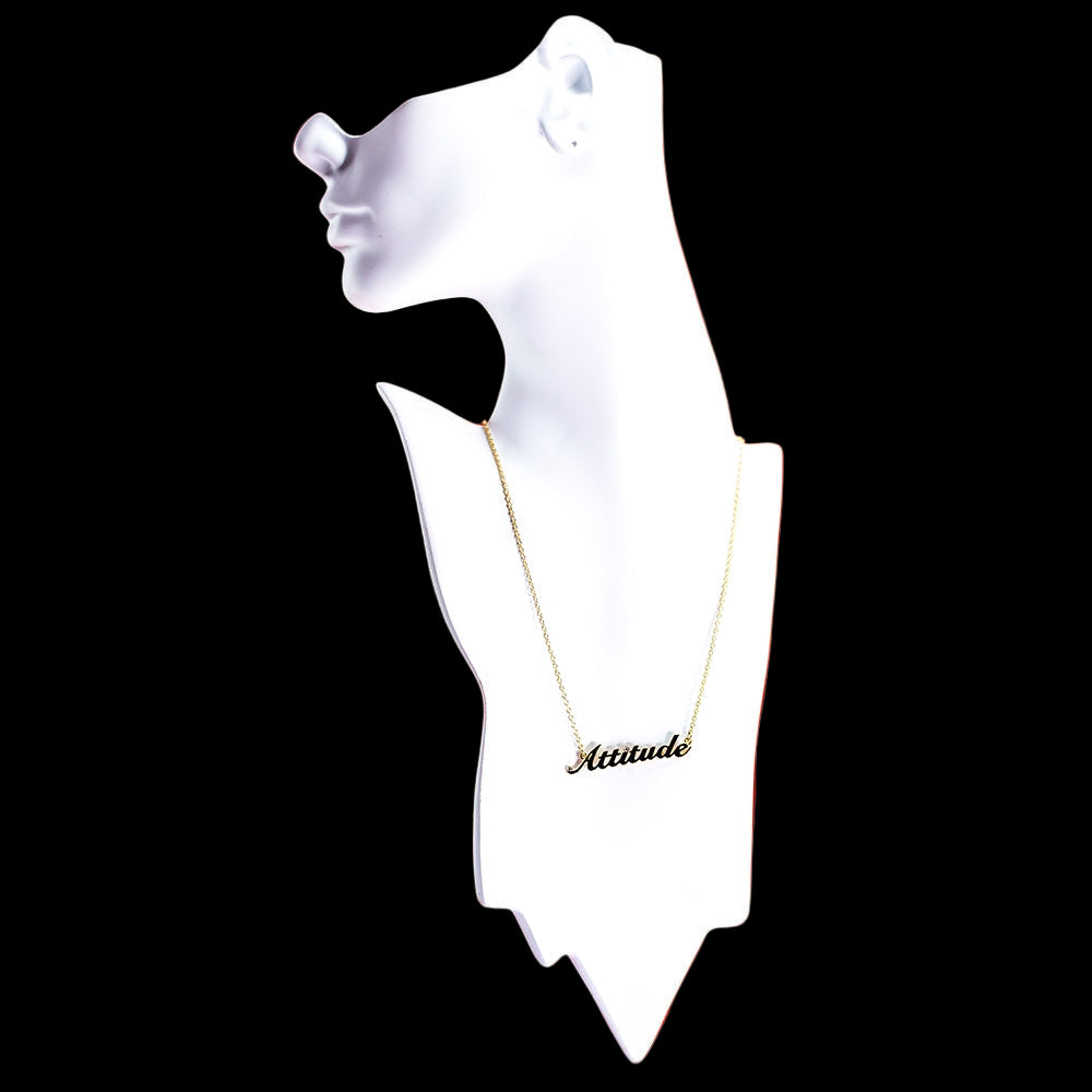 Gold necklace with 'Attitude' pendant on a white display bust.