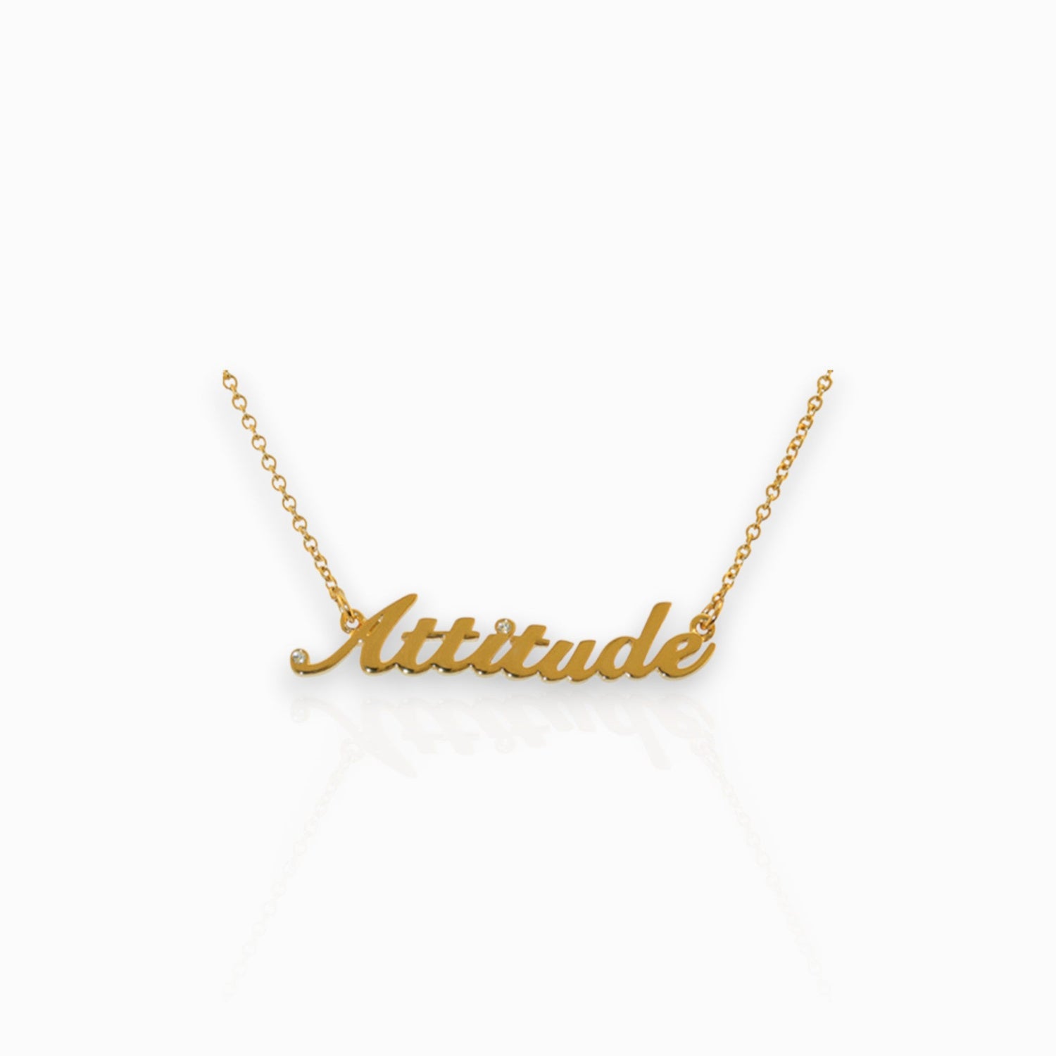 Gold necklace with 'Attitude' pendant on a white background