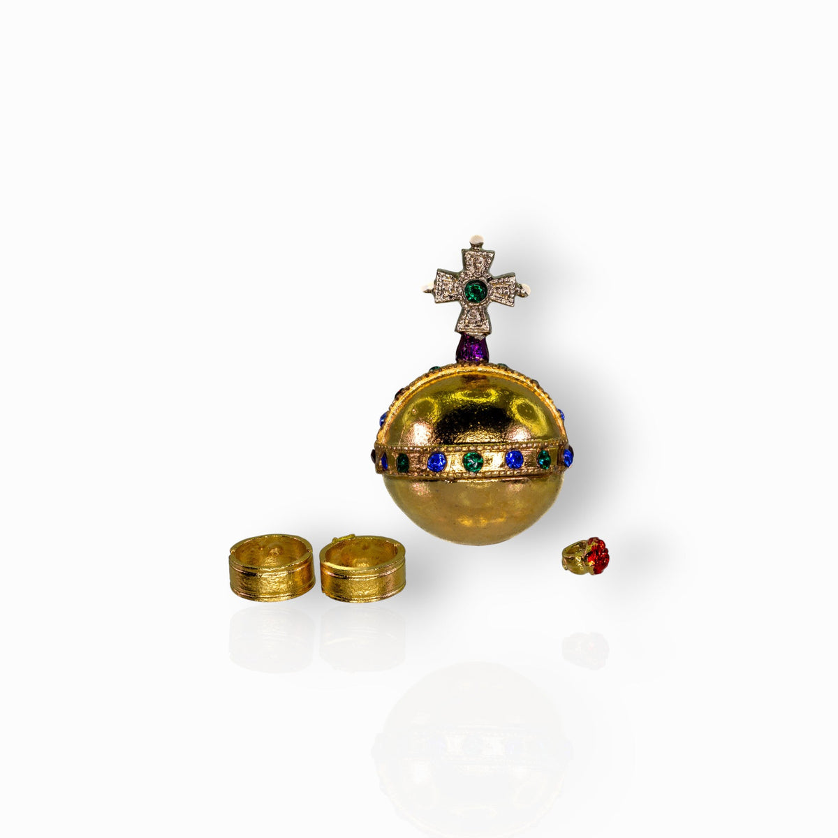 Decorative gold sphere with gemstones and a cross on a white background.