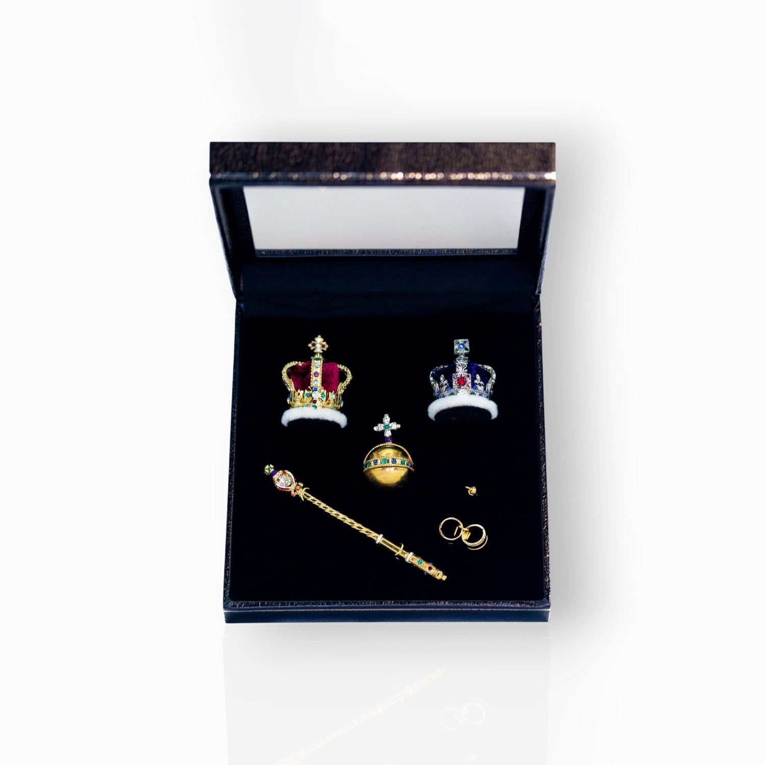 Set of miniature crowns and regalia in a box on a white background.