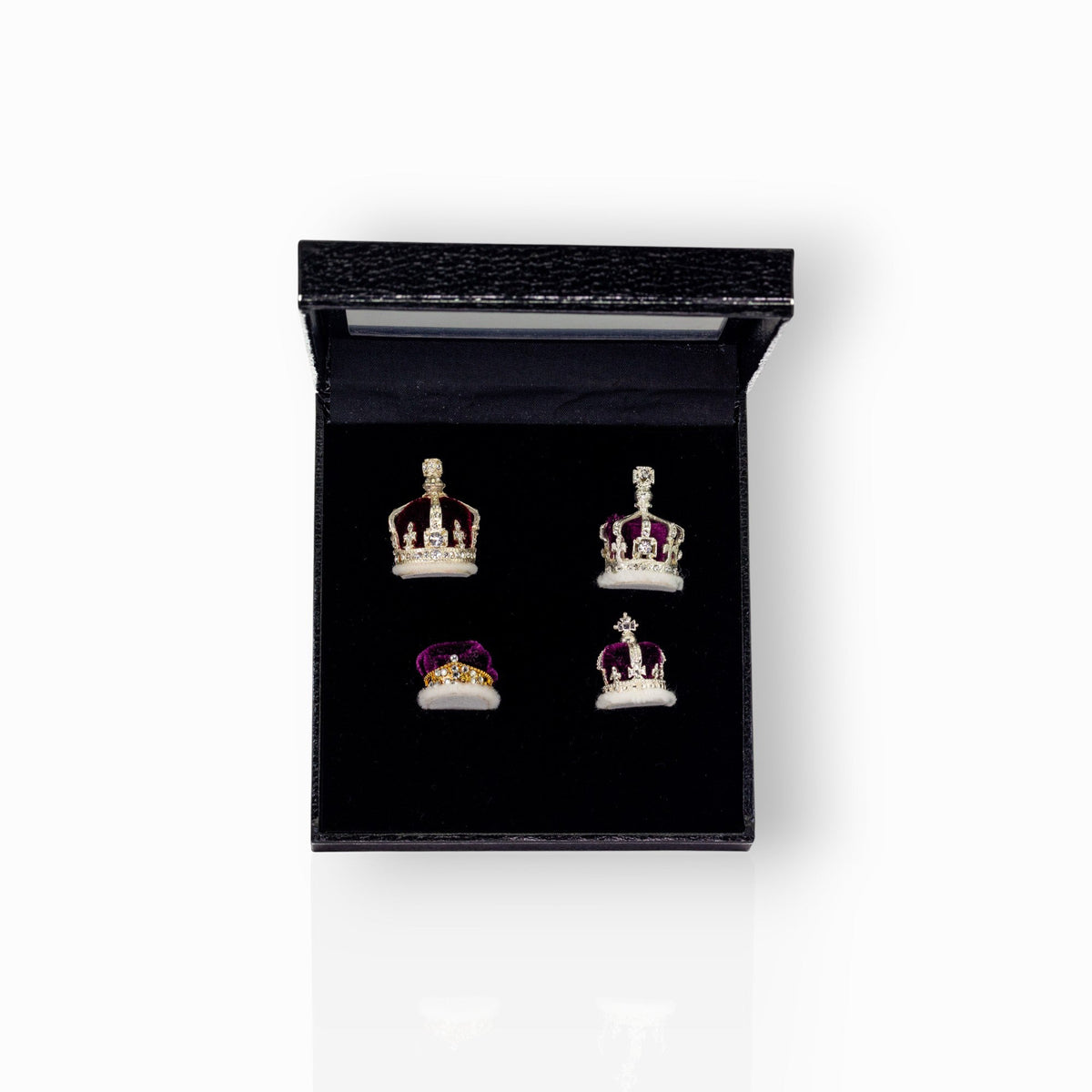 Set of crown-shaped earrings in a black display box.