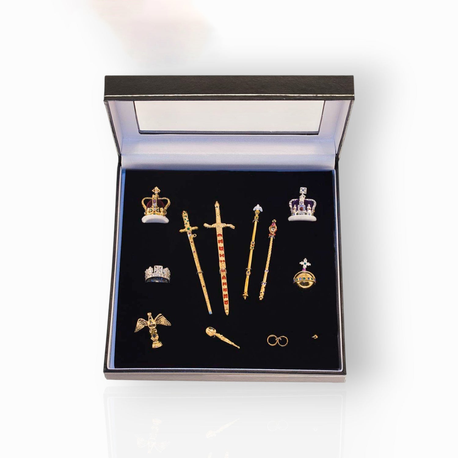 Set of decorative items including crowns and swords in a box on a white background.