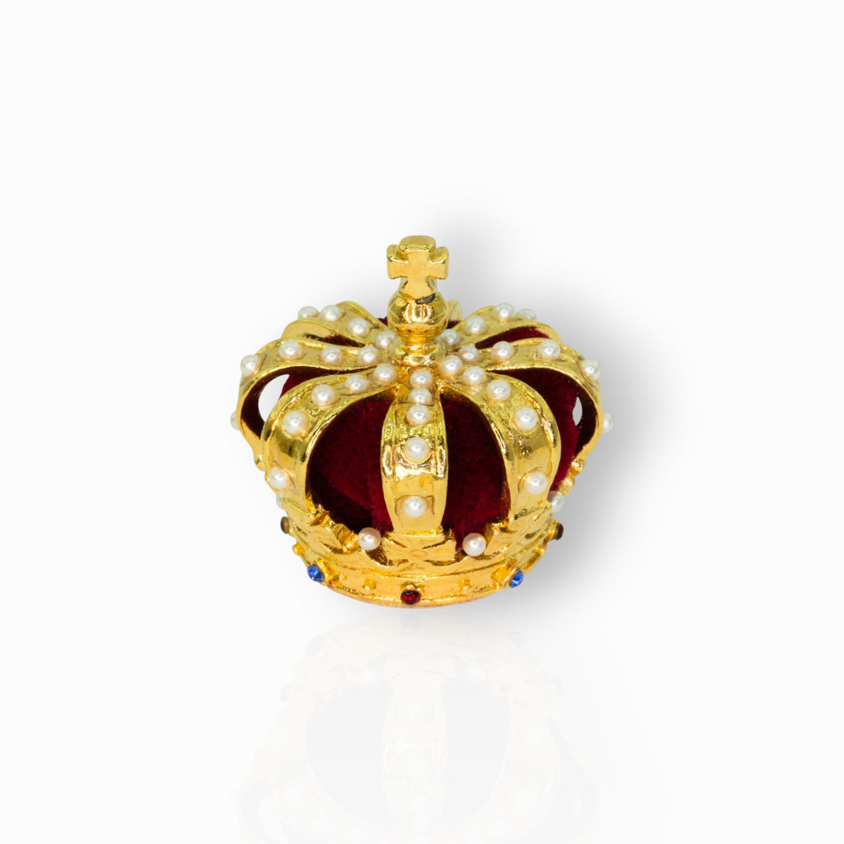 Gold crown with pearls and red center on a white background.