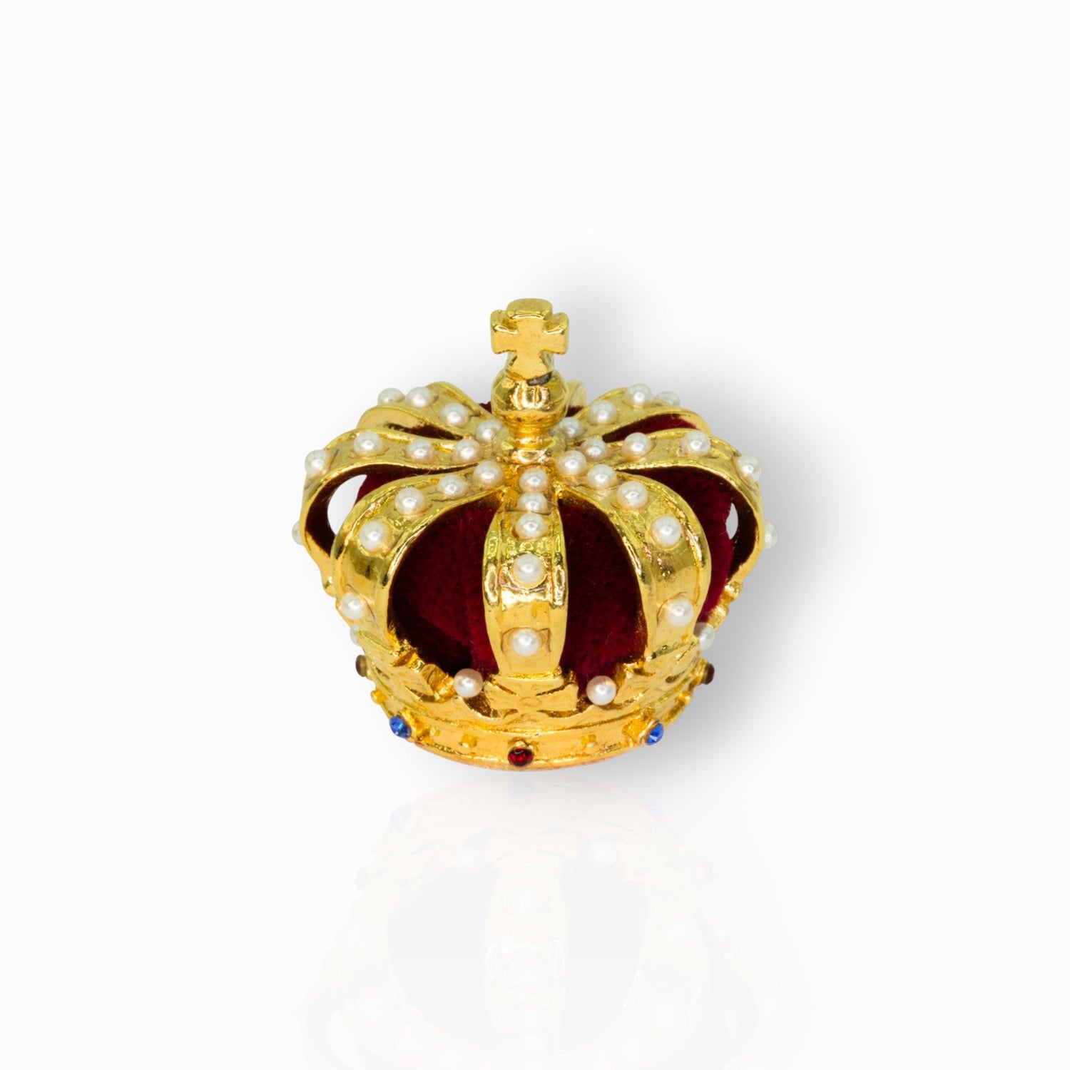 Gold crown with pearls and red center on a white background.