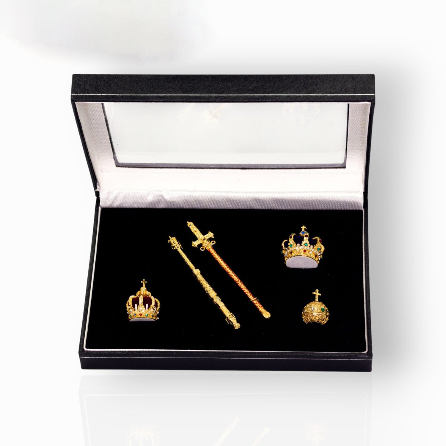 Set of gold crowns and scepter in a box on a white background.