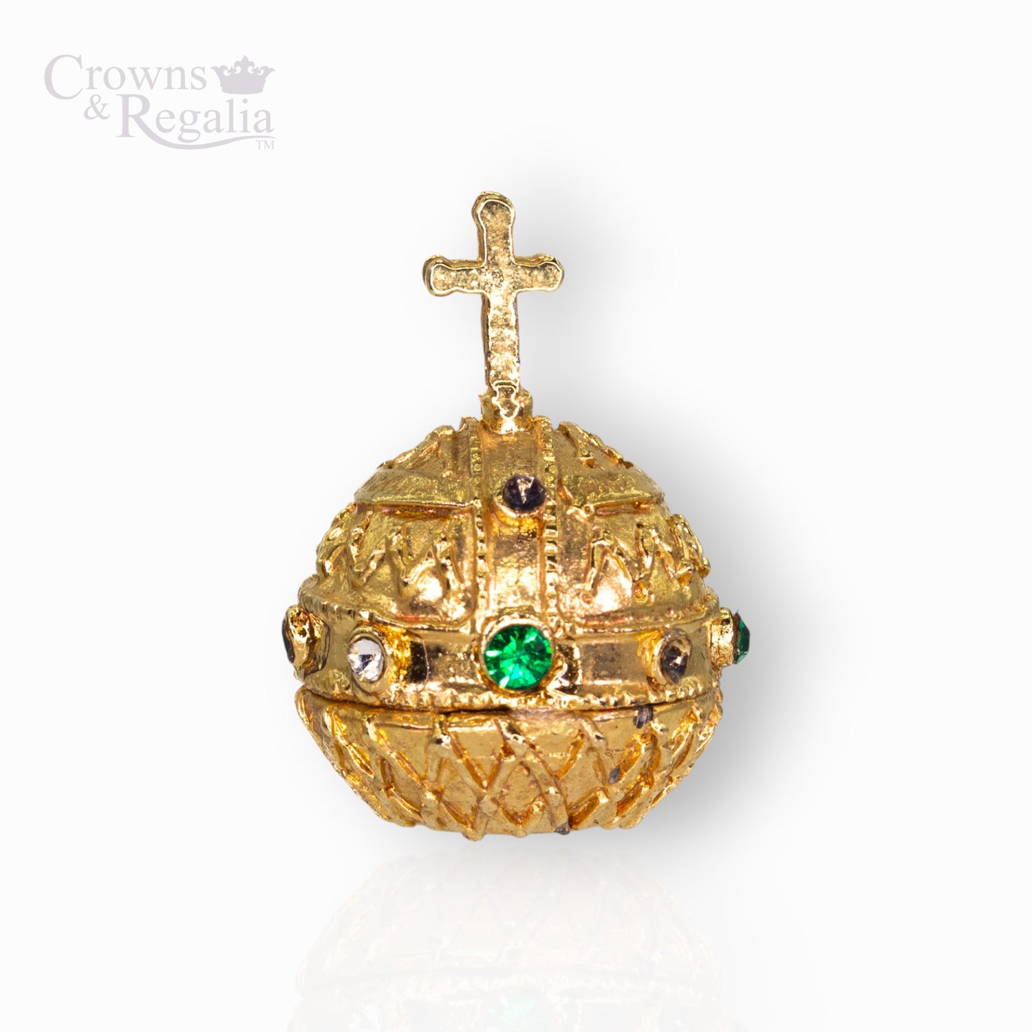 Gold decorative sphere with a cross on top and green gemstones.