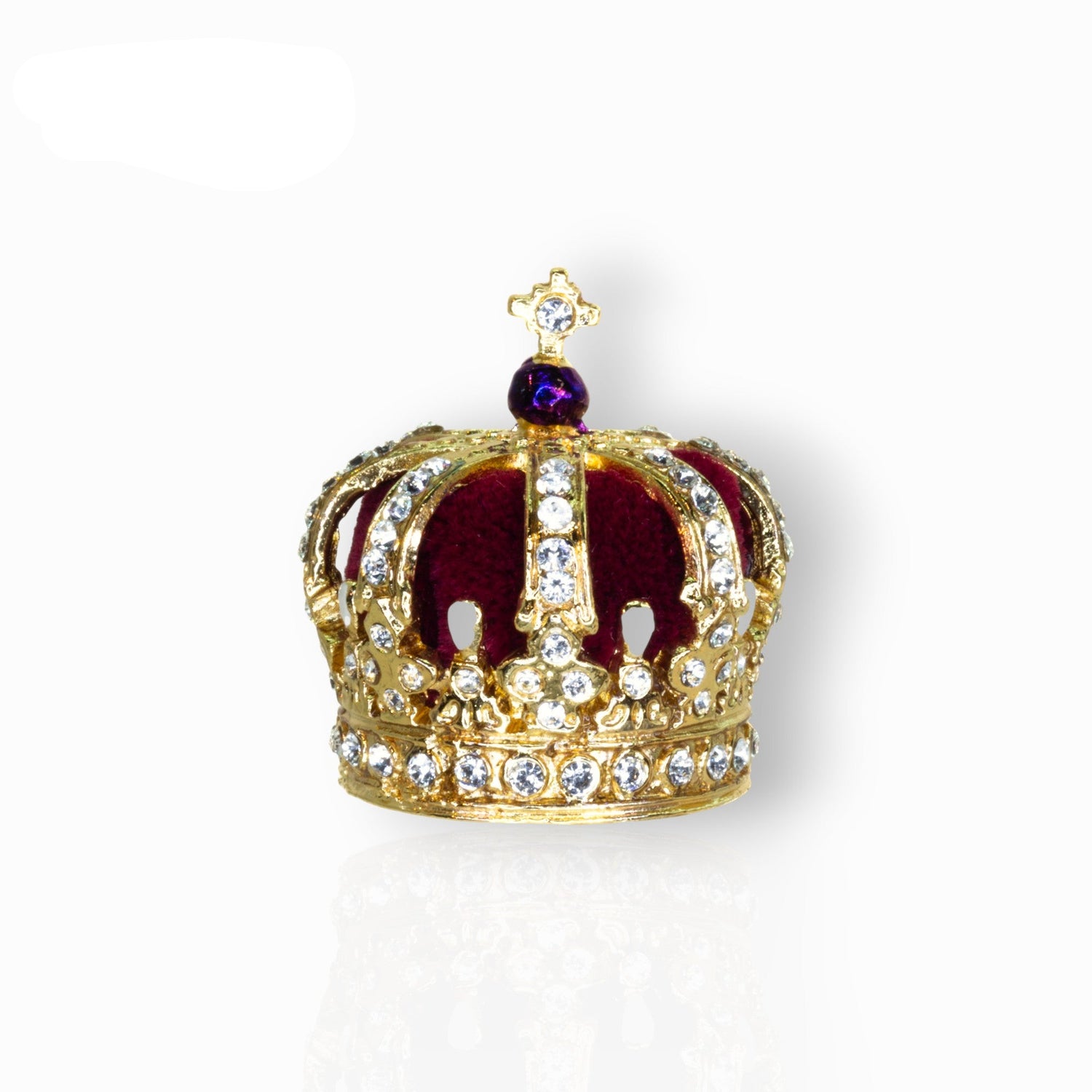 Gold crown with red center and centre piece on a white background.