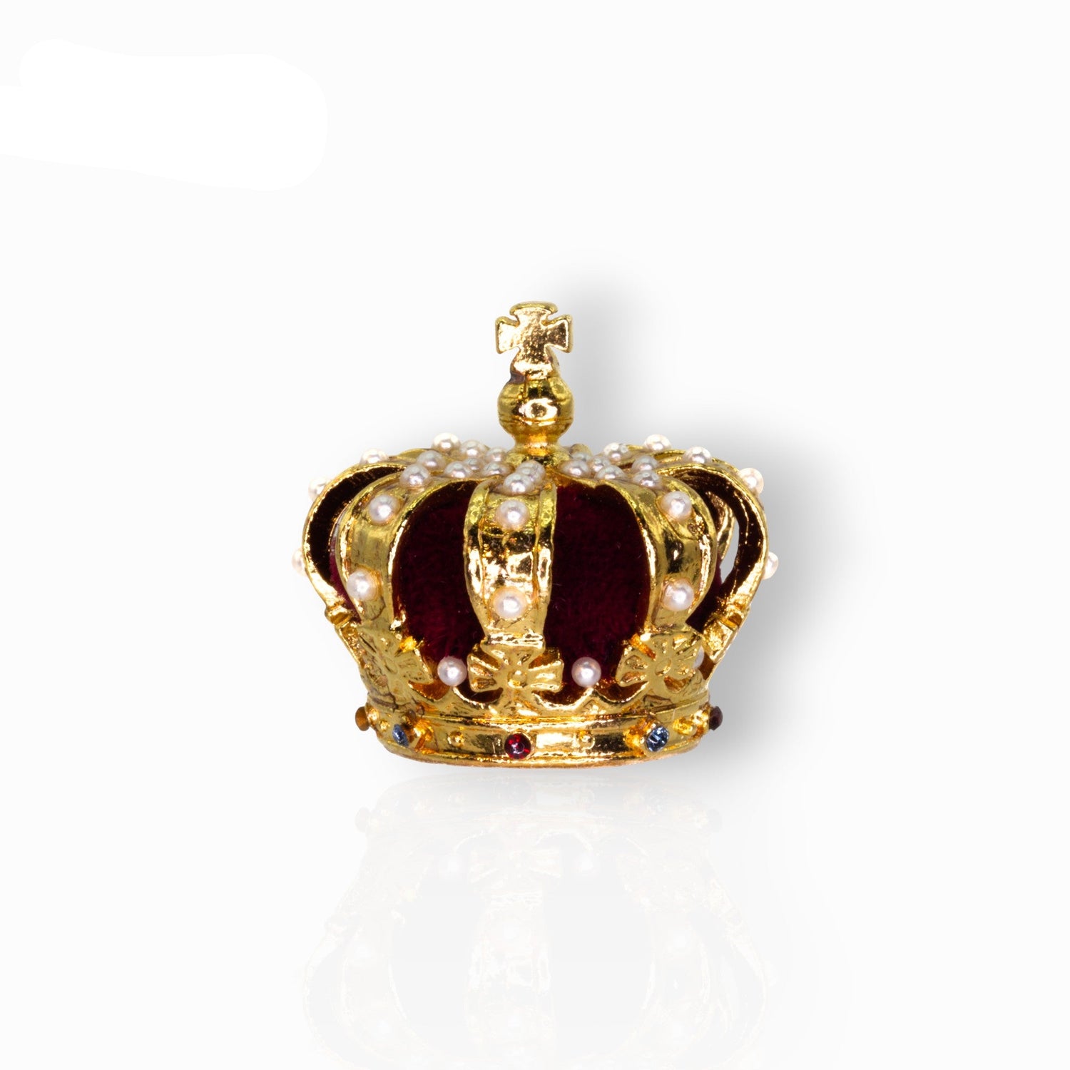 Gold crown with pearls and gemstones on a white background.