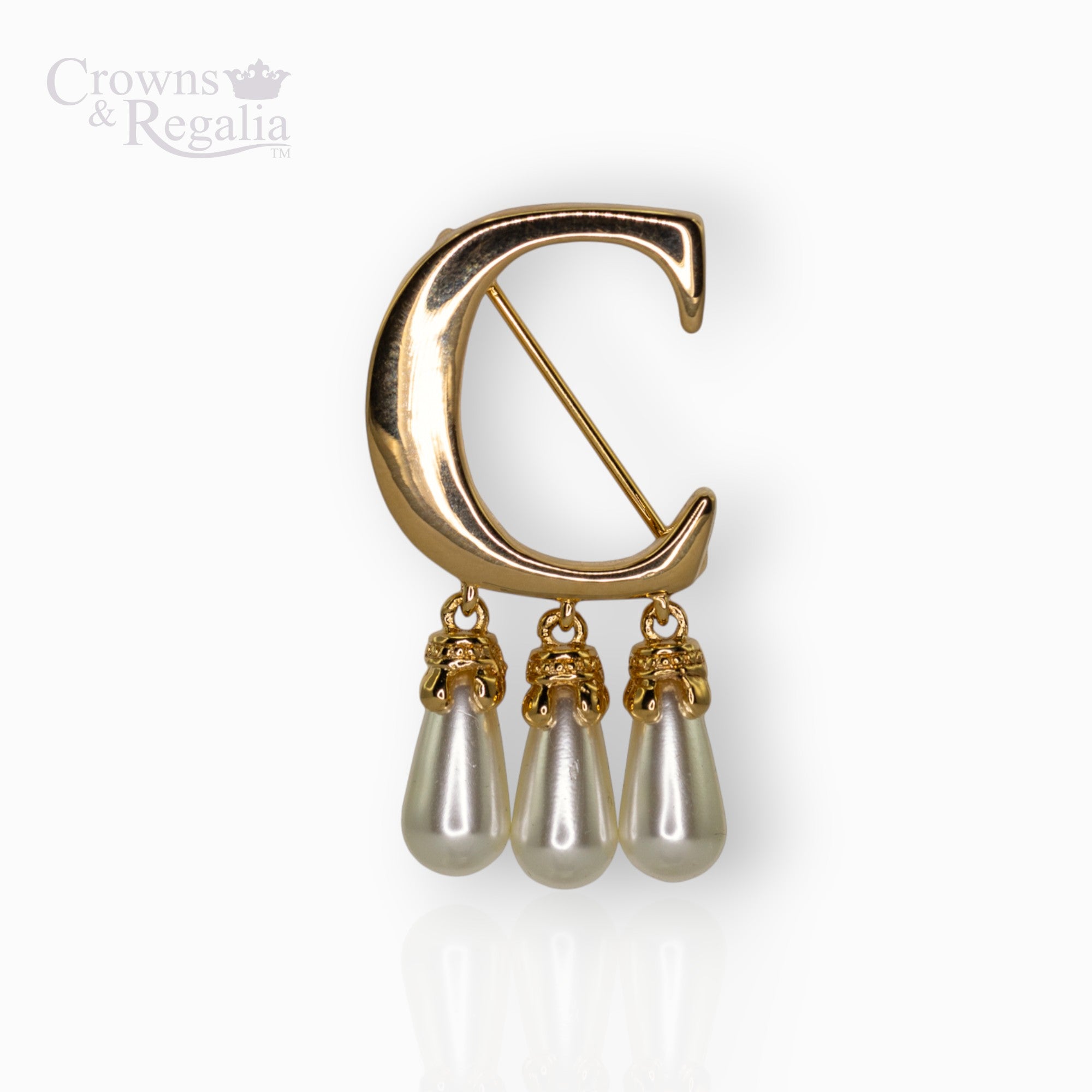 Gold brooch with a "C" design and pearl-like droplets on a white background, branded 'Crowns & Regalia'.