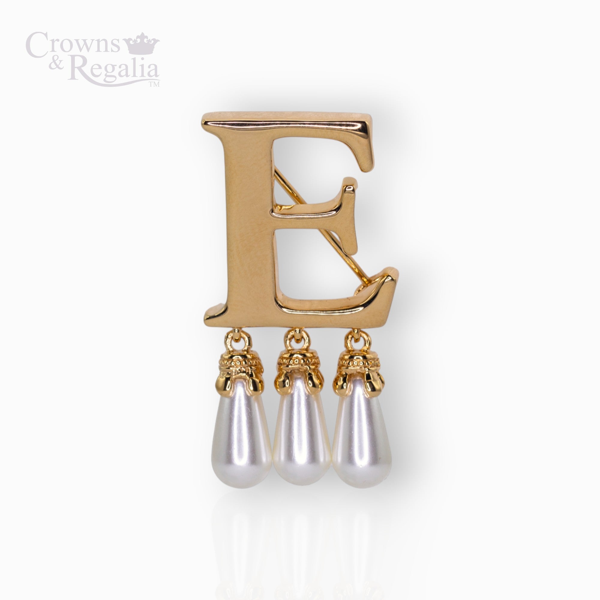 Gold brooch with letter 'E' and pearl-like droplets on a white background, branded 'Crowns & Regalia'.