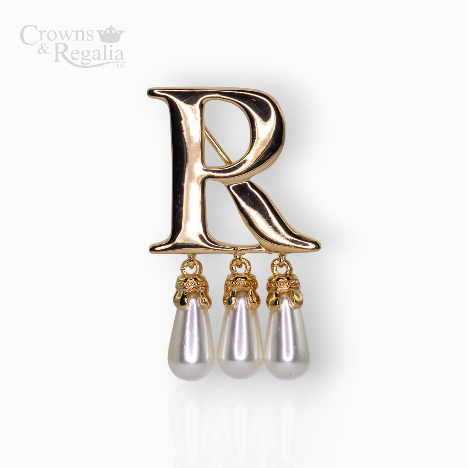 Gold brooch with letter 'R' and pearl drops on a white background.