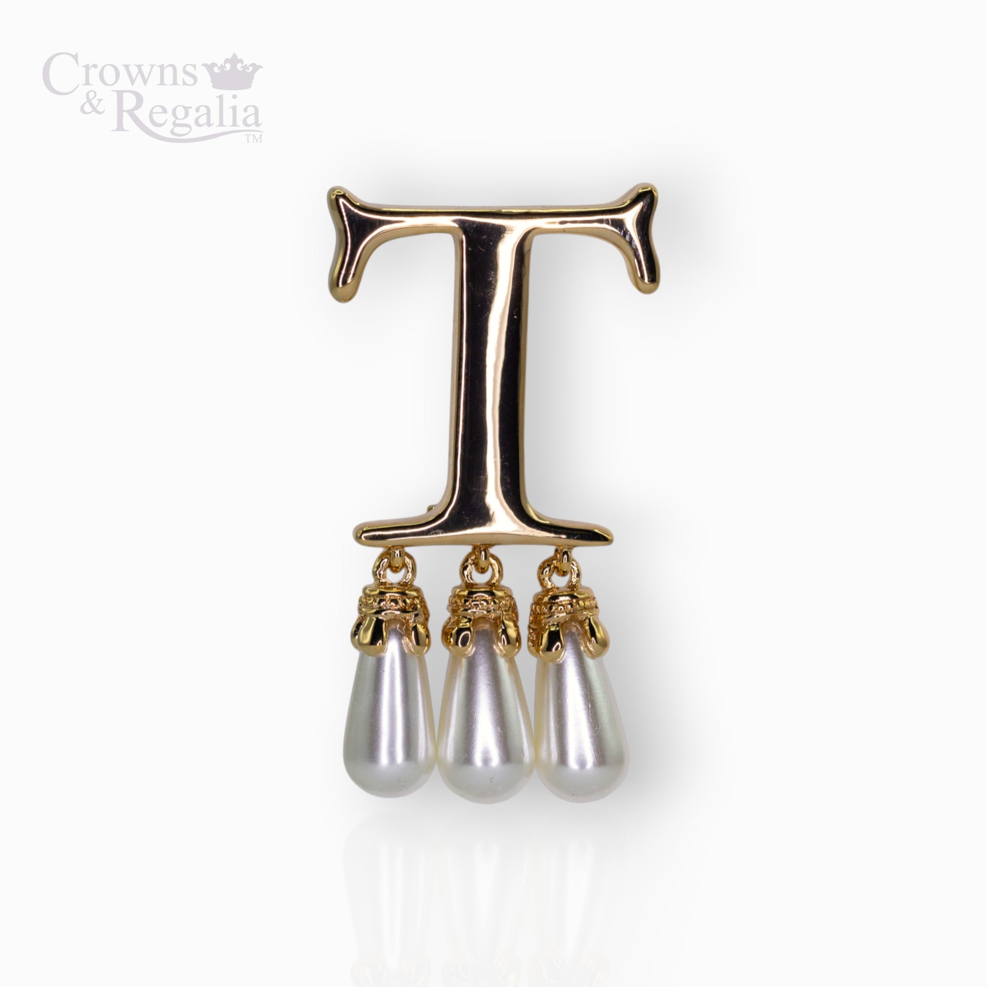 Gold brooch with letter 'T' and pearl drops on a white background, branded 'Crowns & Regalia'.