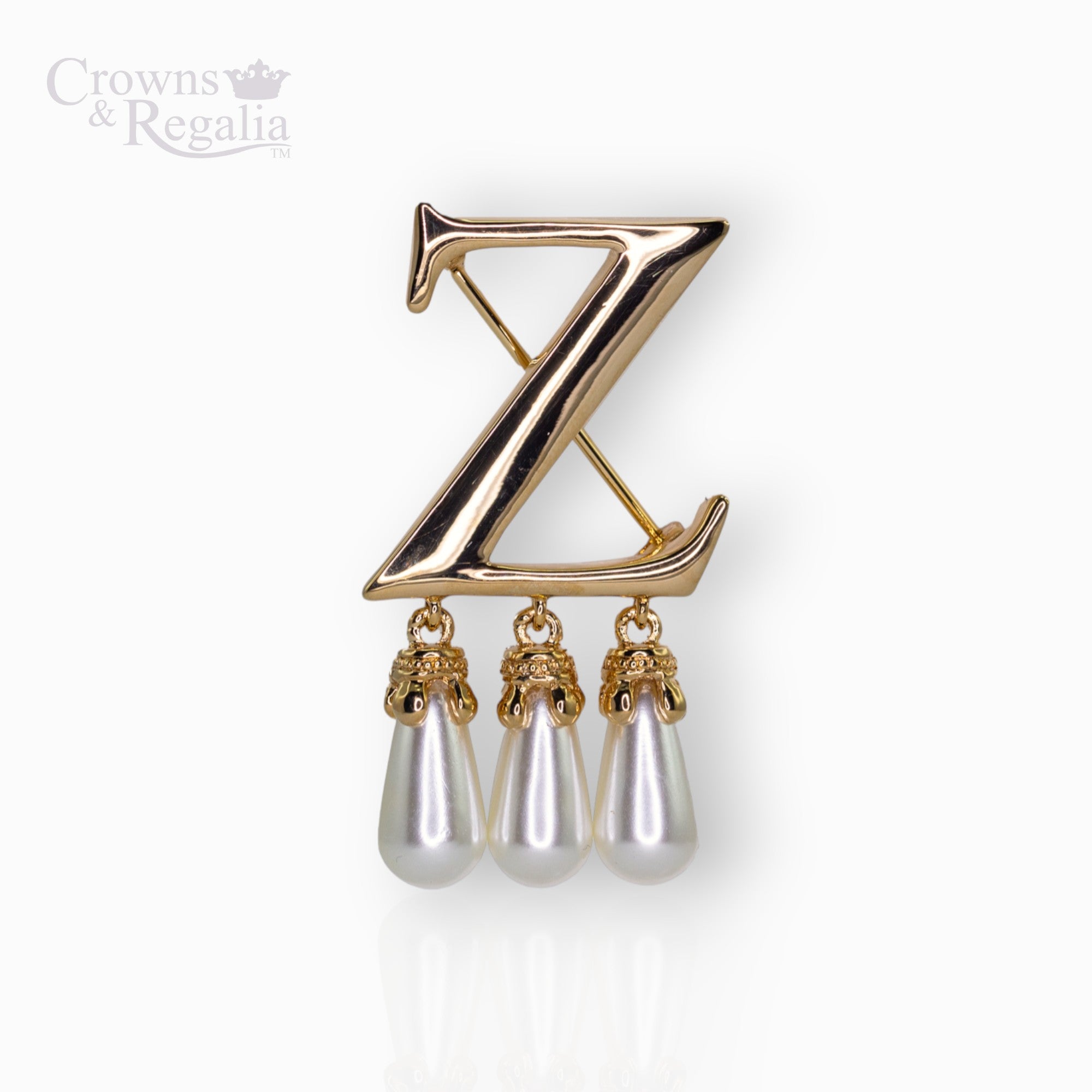 Gold brooch with 'Z' design and pearl-like droplets on a white background, branded 'Crowns & Regalia'.