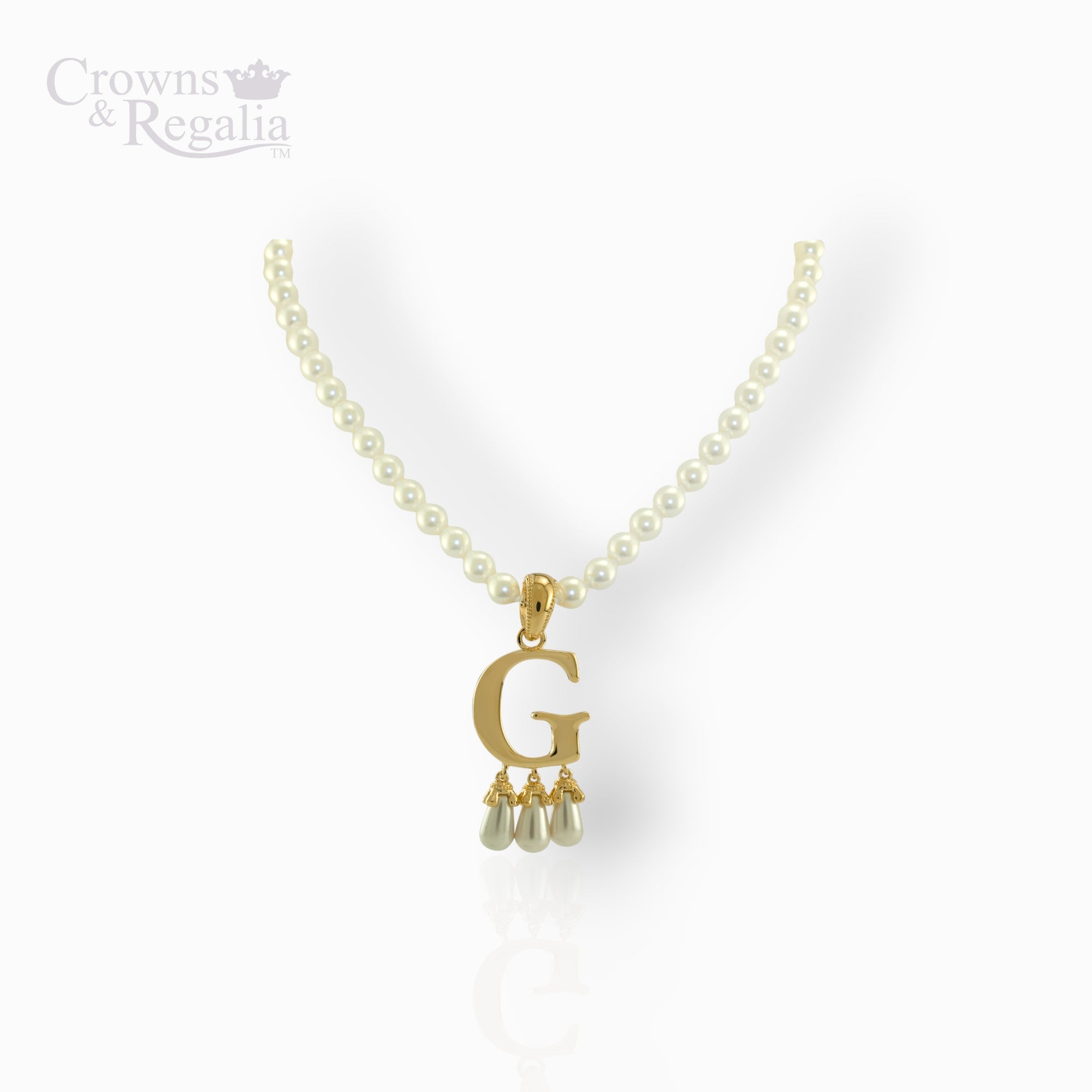 Gold necklace with 'G' pendant and pearl drops on a white background, branded 'Crowns & Regalia'.