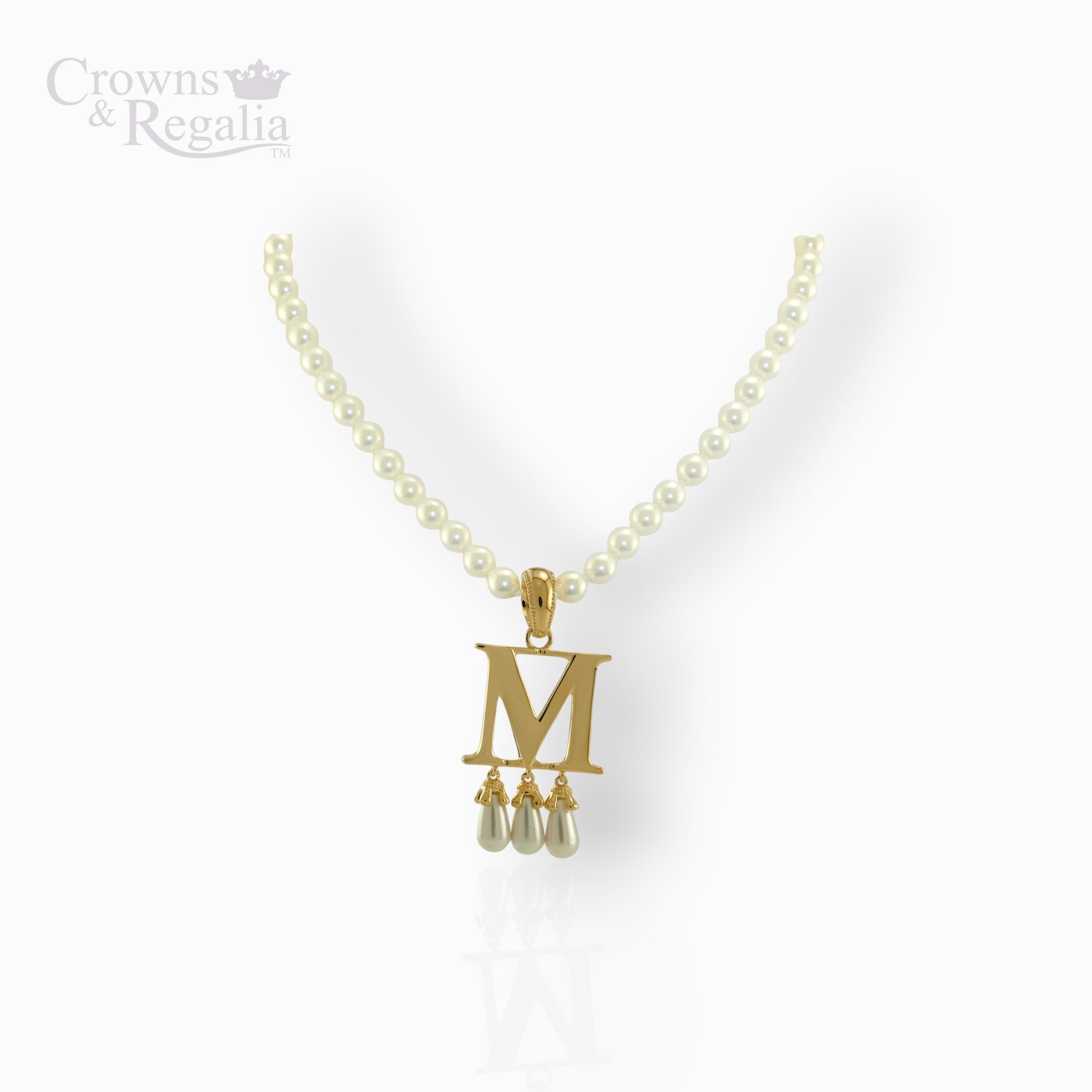 Pearl necklace with a gold pendant featuring the letter 'M' on a white background, branded 'Crowns & Regalia'.