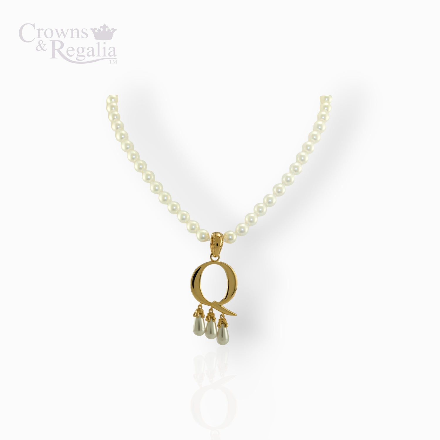 Gold pendant with three small pearls on a pearl necklace against a white background.
